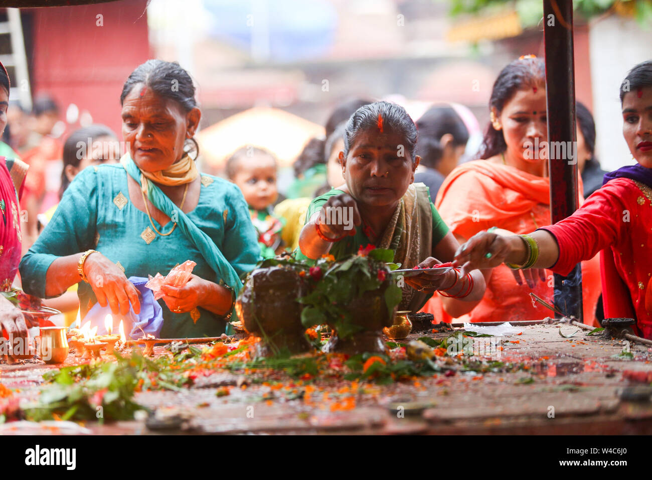 Kathmandu, Nepal. 22nd July, 2019. Devotees perform rituals at the Shiva temple during a Shrawan Sombar festival.Shrawan month is considered as the holiest month of the year and each Somvar (Monday) of this month is known as Shrawan Somvar, during which devotees fast and worship Lord Shiva to pray for happiness for their families. Credit: SOPA Images Limited/Alamy Live News Stock Photo