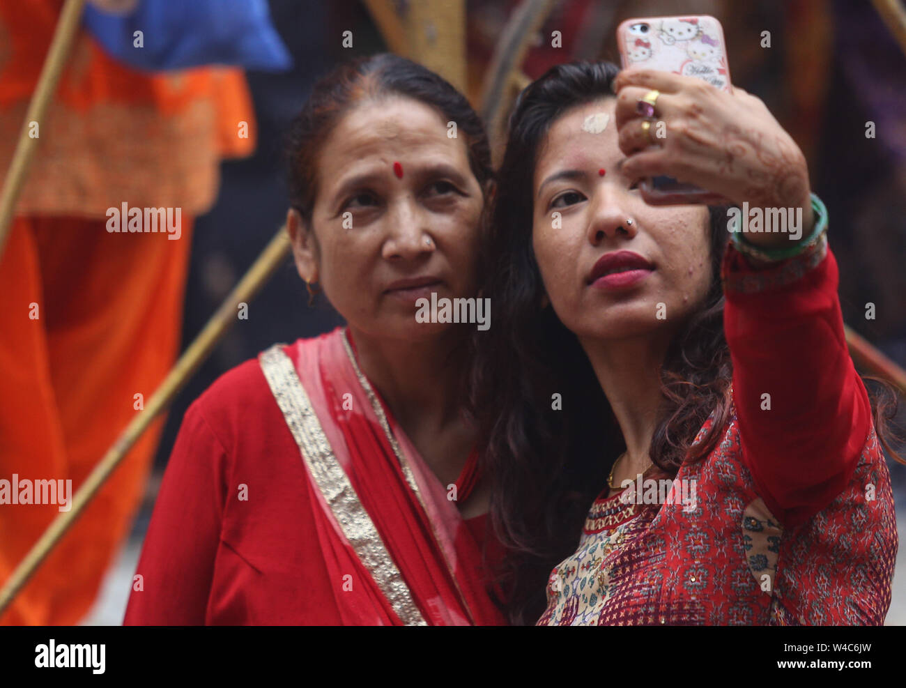 Kathmandu, Nepal. 22nd July, 2019. Women take selfies after giving offering to the Hindu god Lord Shiva, the god of destruction and creation at the Shiva temple during a Shrawan Sombar festival.Shrawan month is considered as the holiest month of the year and each Somvar (Monday) of this month is known as Shrawan Somvar, during which devotees fast and worship Lord Shiva to pray for happiness for their families. Credit: SOPA Images Limited/Alamy Live News Stock Photo