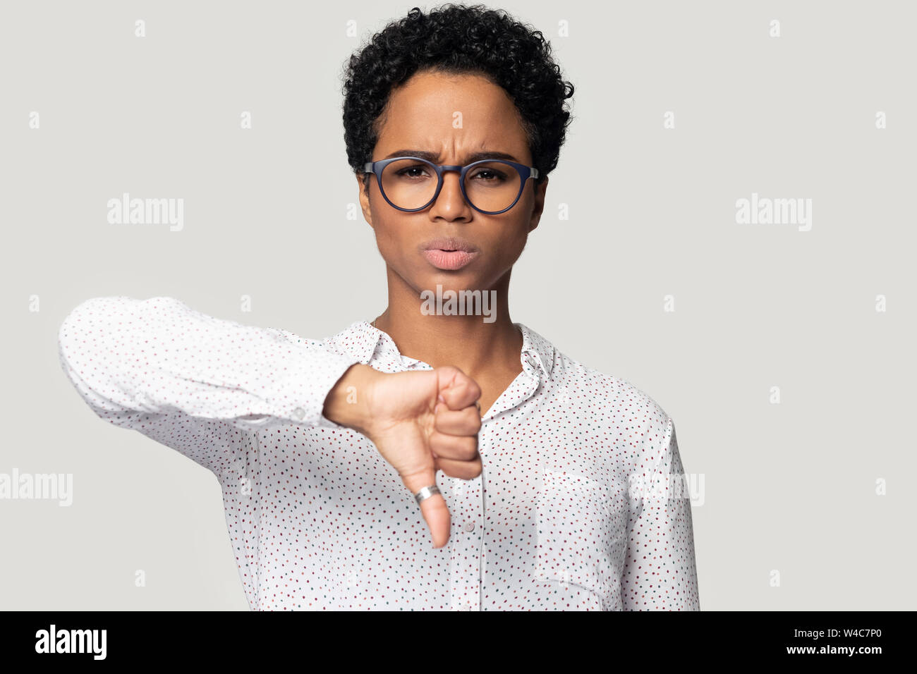 Unhappy biracial woman show thumb down disliking service Stock Photo