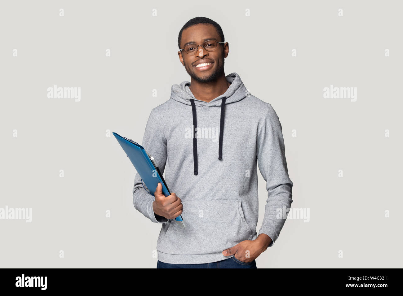 Smiling black male student stand holding binder case Stock Photo