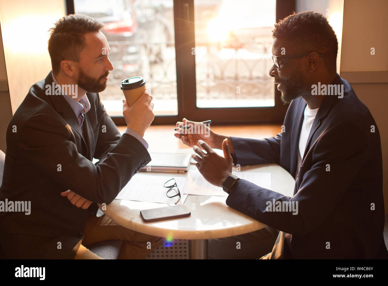 Two businessmen having a coffee break in the cafe. Stock Photo