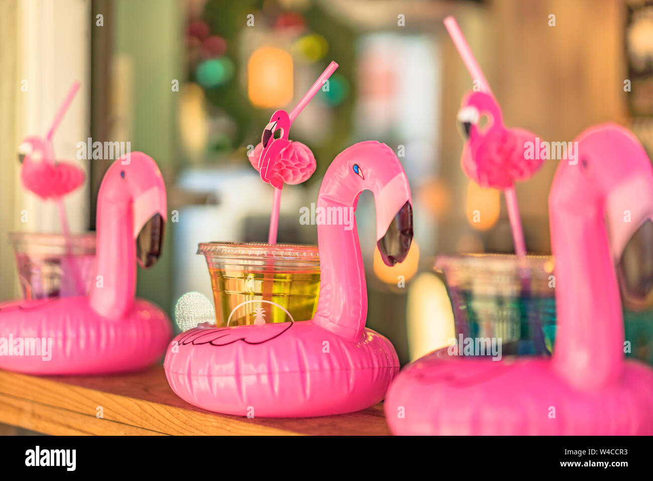 Cocktail glass with a flamingo-shaped straw and buoy aligned on a bar counter in Mihama Town Resort American Village Stock Photo