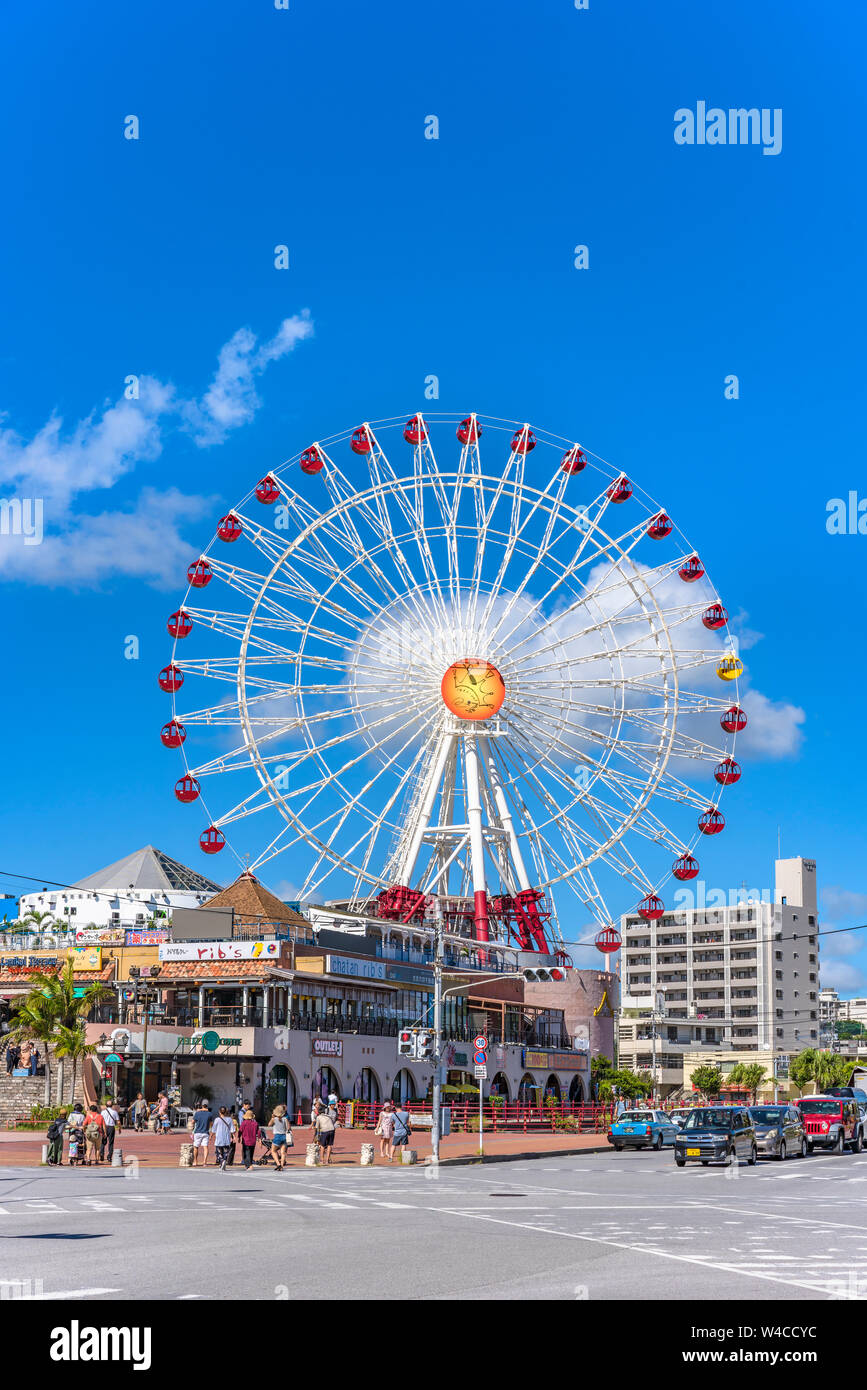 American Village, Japan - September 17 2018: Chatan City red steel bridge and Mihama Carnival Park Ferris wheel in the American Village Stock Photo