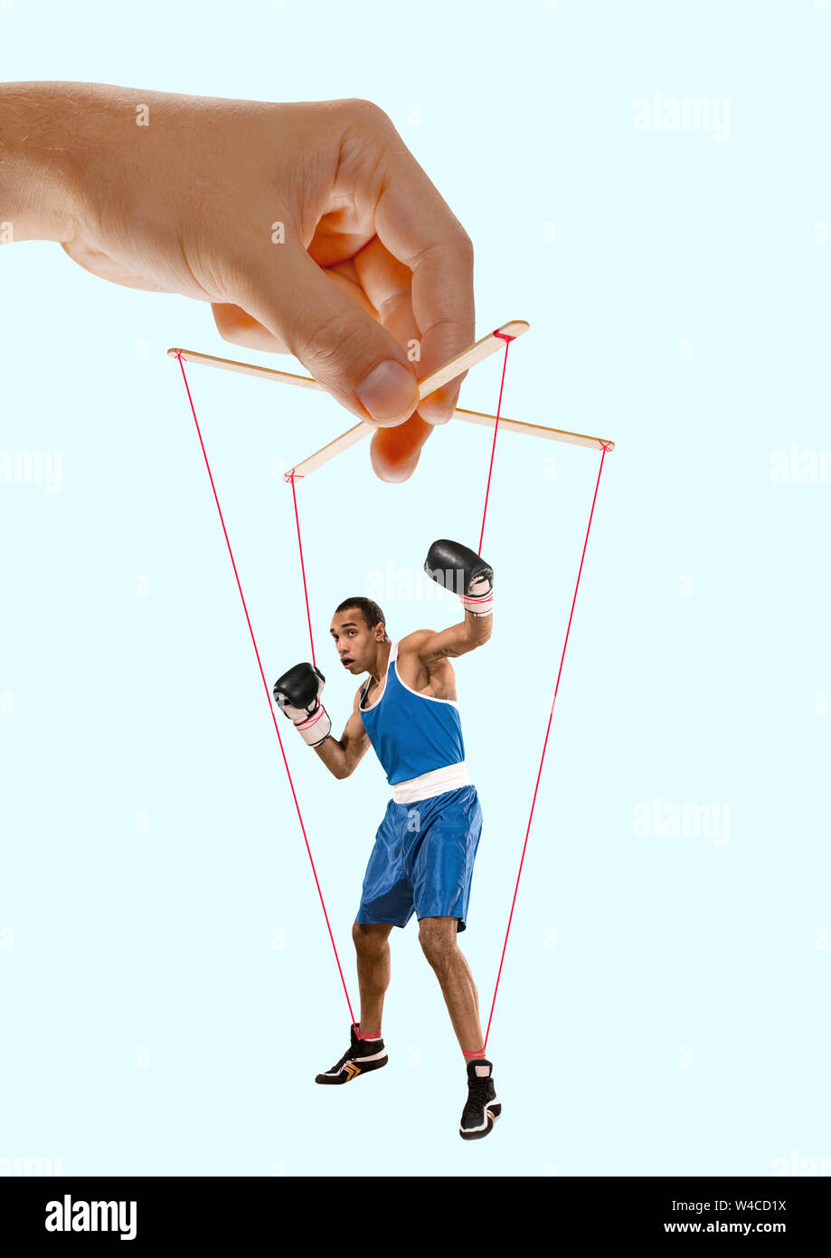 Hand Puppet Mocking Man like a puppet in somebodies hands on blue background. Concept of ...