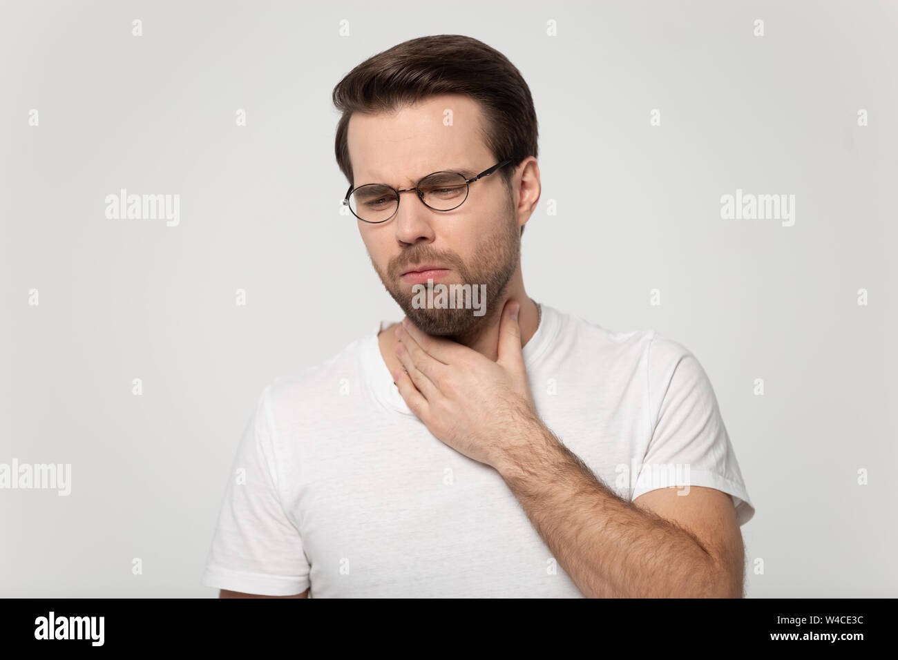 Young guy coughing having sore throat studio shot Stock Photo