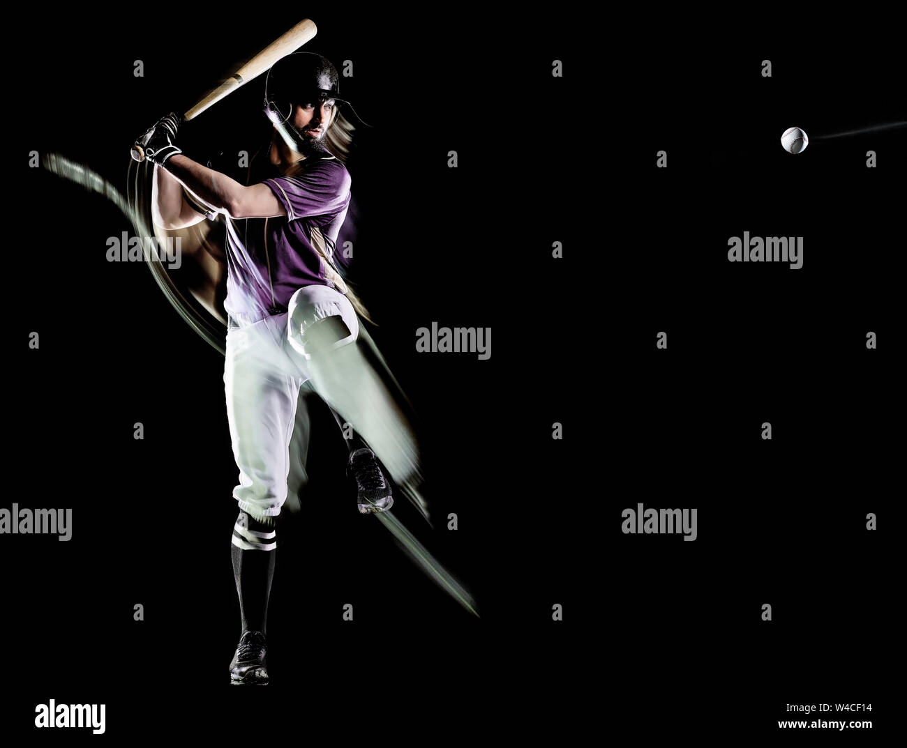 one caucasian baseball player man  studio shot isolated on black background with light painting speed effect Stock Photo
