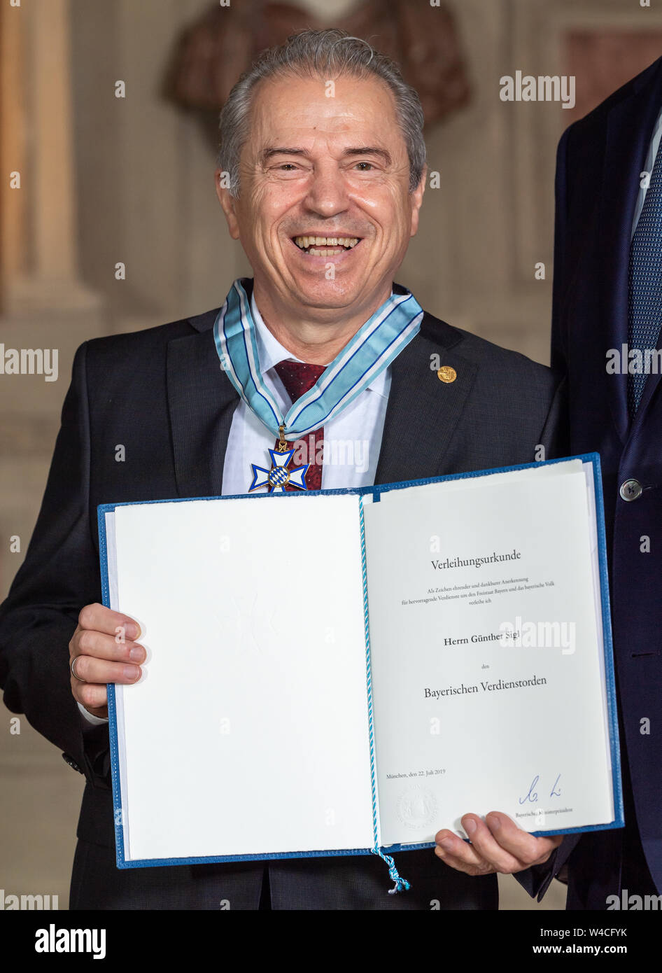 Munich, Germany. 22nd July, 2019. The musician Günther Sigl from the village Gräfelfing shows his award at the awarding of the Bavarian Order of Merit. Credit: Peter Kneffel/dpa/Alamy Live News Stock Photo