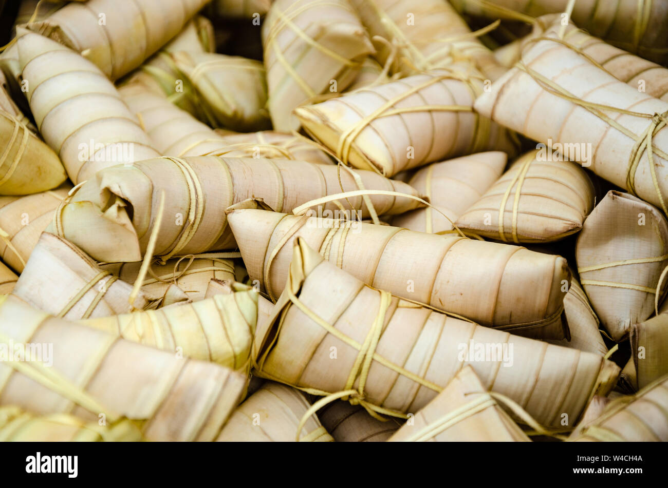 Suman is a Filipino snack or dessert and is a sweet, white sticky rice cake which is wrapped in palm leaves and steamed. Often sold as street food Stock Photo