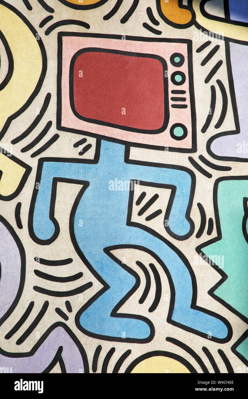 Man with a TV instead of the head painted by Keith Haring. Detail from a huge outdoor artwork (called Tuttomondo) painted in Pisa, Italy, in 1989. Stock Photo