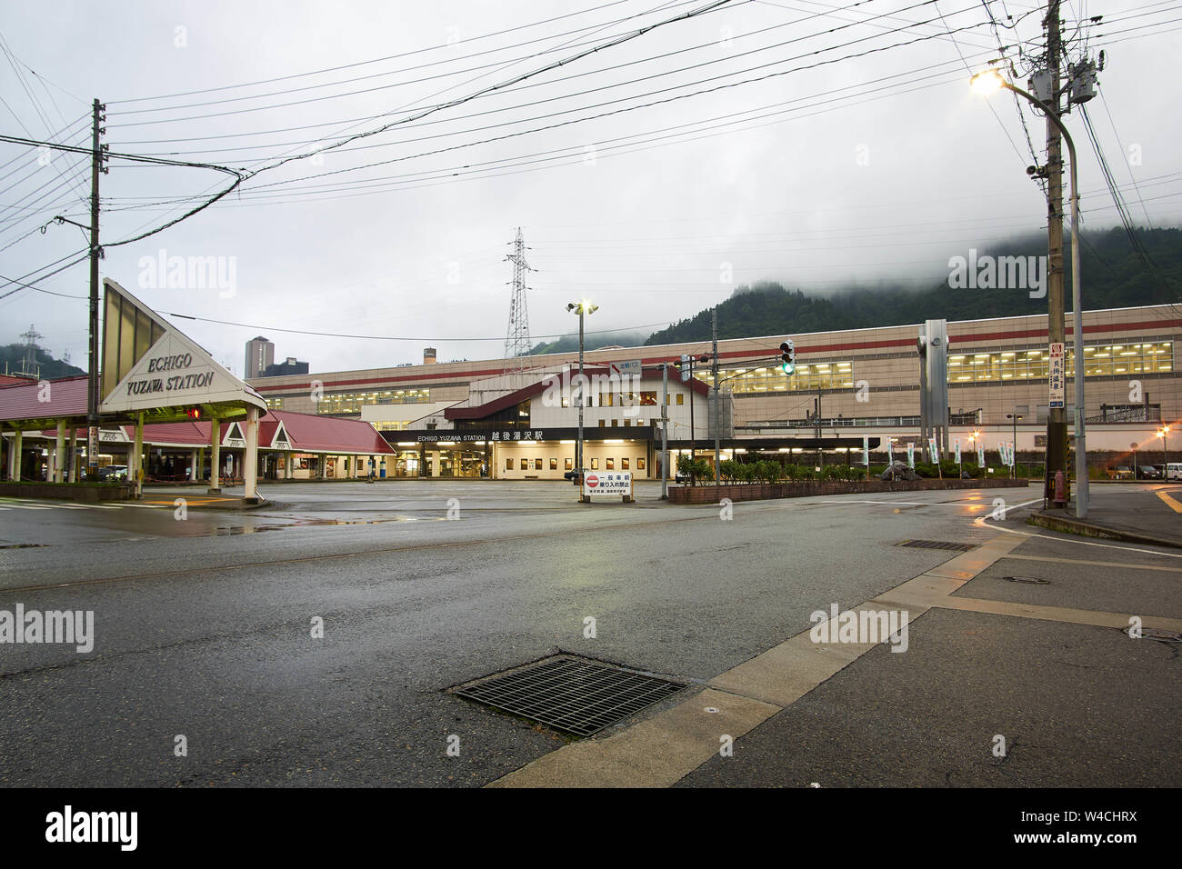 Empty road and bus terminal on the East Exit of Echigo-Yuzawa Station on a cloudy, rainy day in in the rainy season in Yuzawa, Niigata, Japan. Stock Photo