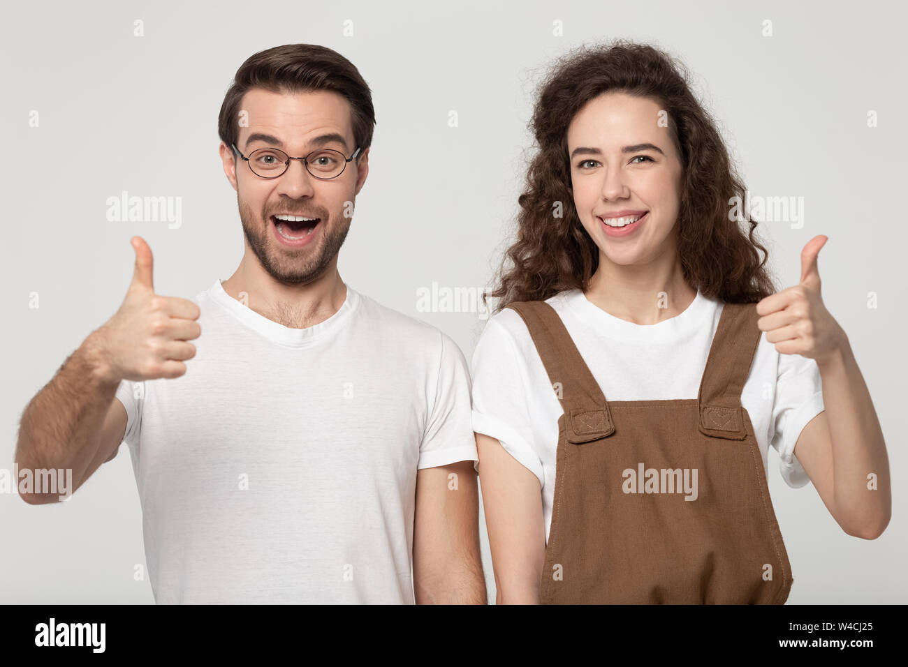 Young couple feels happy showing thumbs up studio shot Stock Photo