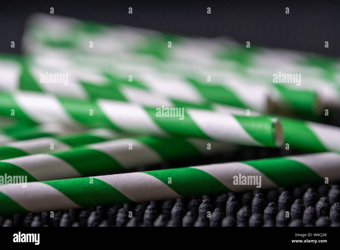 Green and white striped paper drinking straws photographed in a bar in