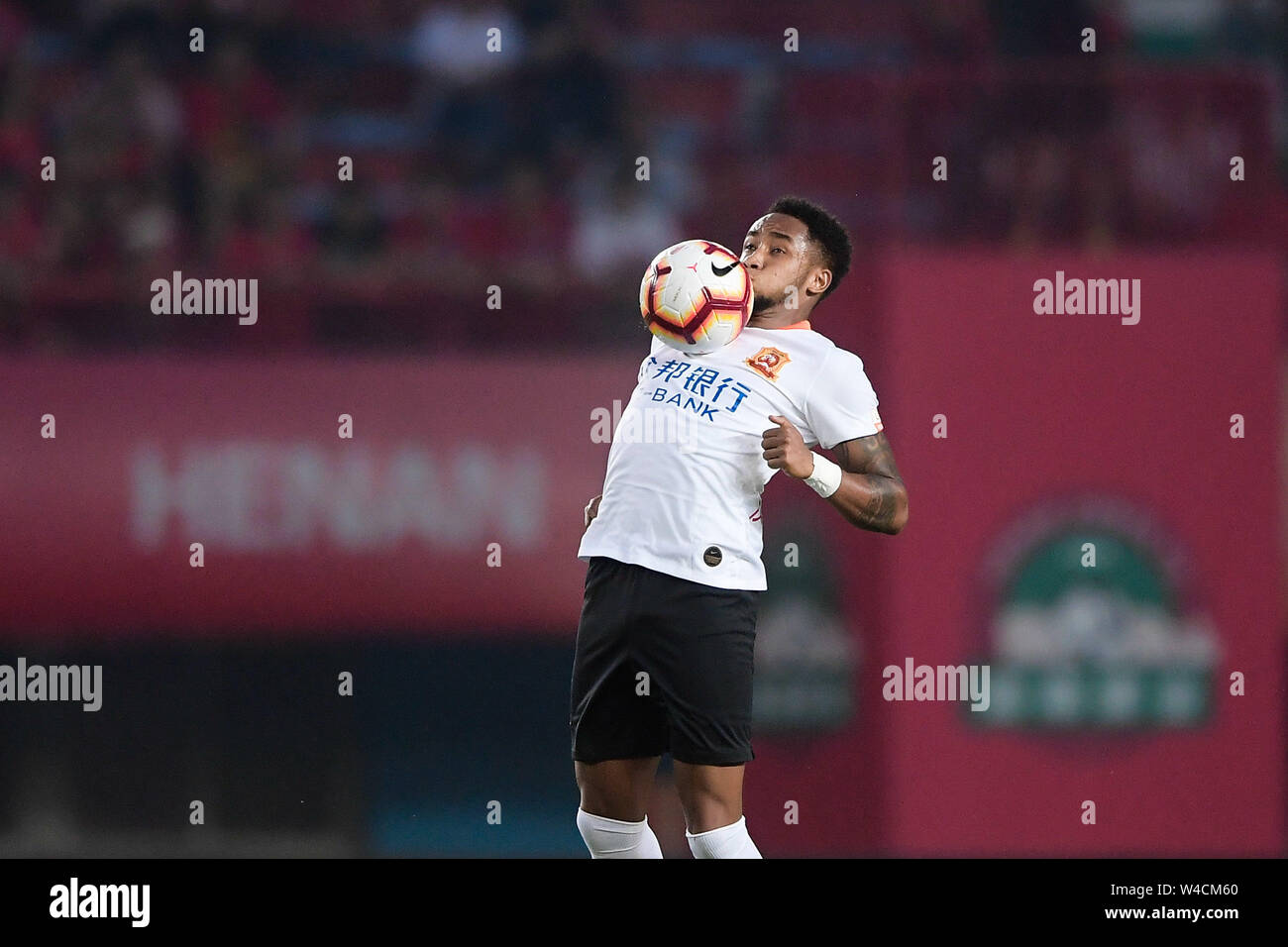 Brazilian football player Rafael Pereira da Silva, commonly known as Rafael or Rafael da Silva, of Wuhan Zall F.C. stops the ball with his chest during the 19th round of Chinese Football Association Super League (CSL) against Henan Jianye in Zhengzhou, central China’s Henan province on 21 July 2019.  The match ened with a draw 0-0. Stock Photo