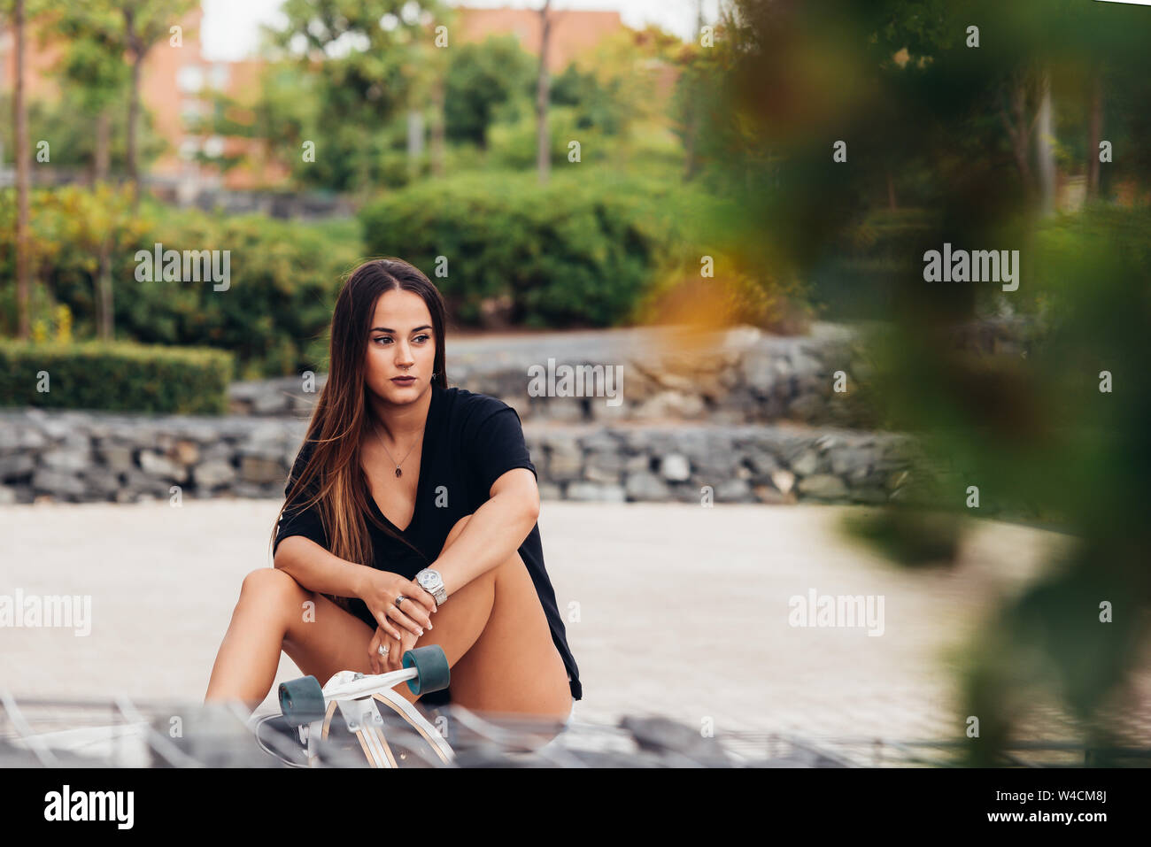 beautiful young woman sitting in park Stock Photo - Alamy
