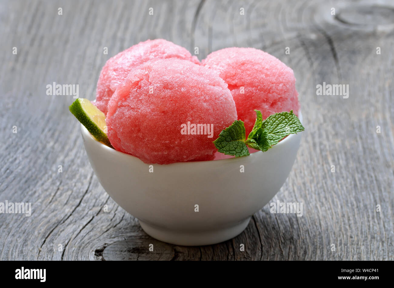 Watermelon sorbet in bowl on wooden table Stock Photo