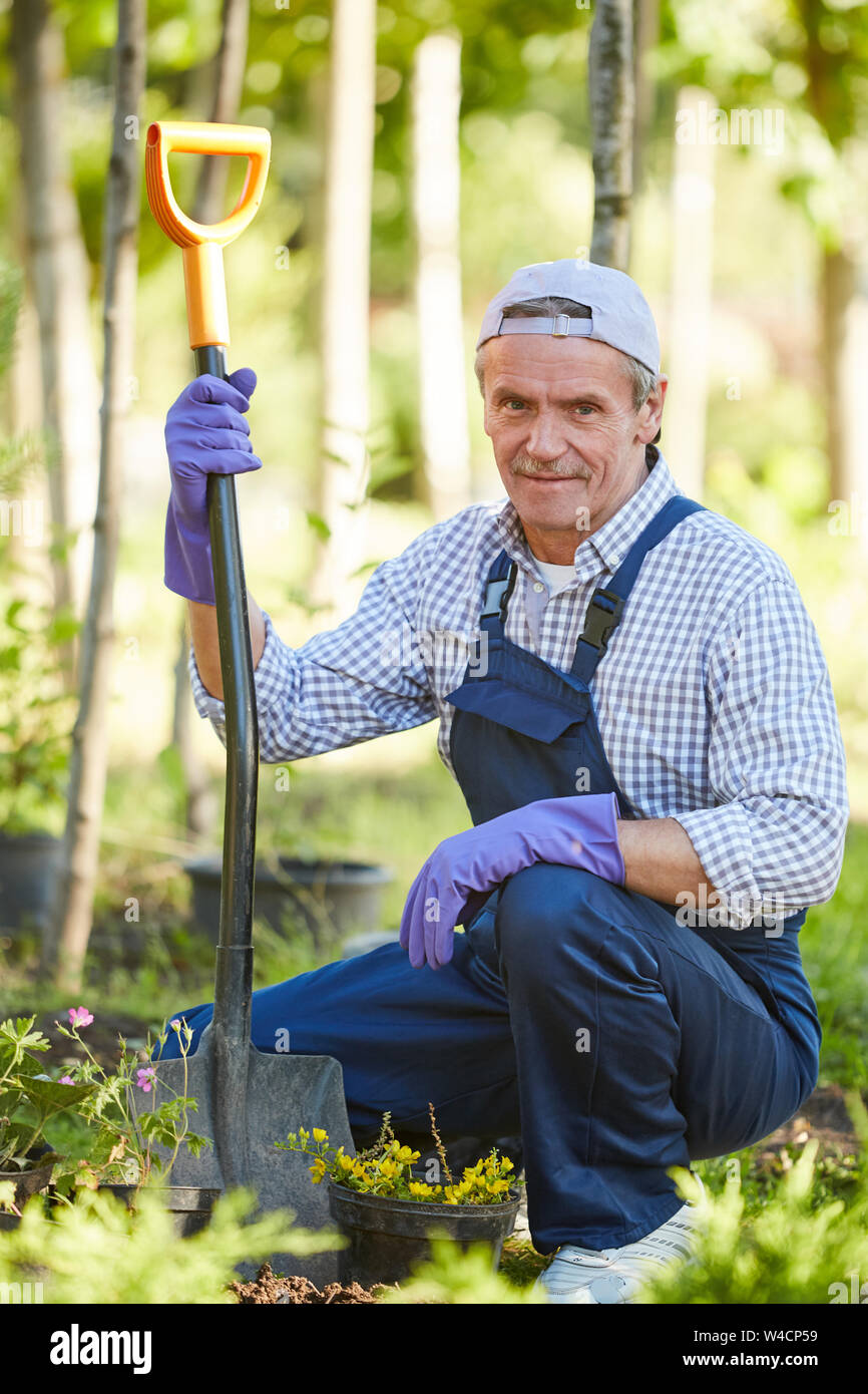 Full length portrait of mature man working in garden and looking at camera Stock Photo