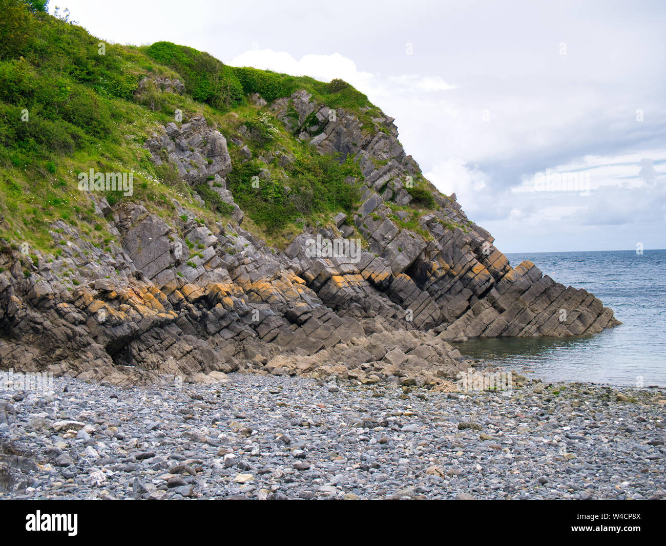 Inclined rock strata in coastal cliffs in Pembrokeshire, South Wales, UK, as viewed from the Coast Path Stock Photo