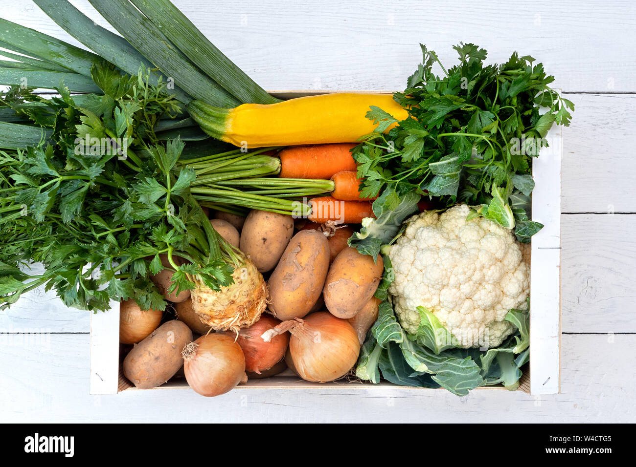 Clioseup of wooden box of fresh vegetables from farmers market on white ...