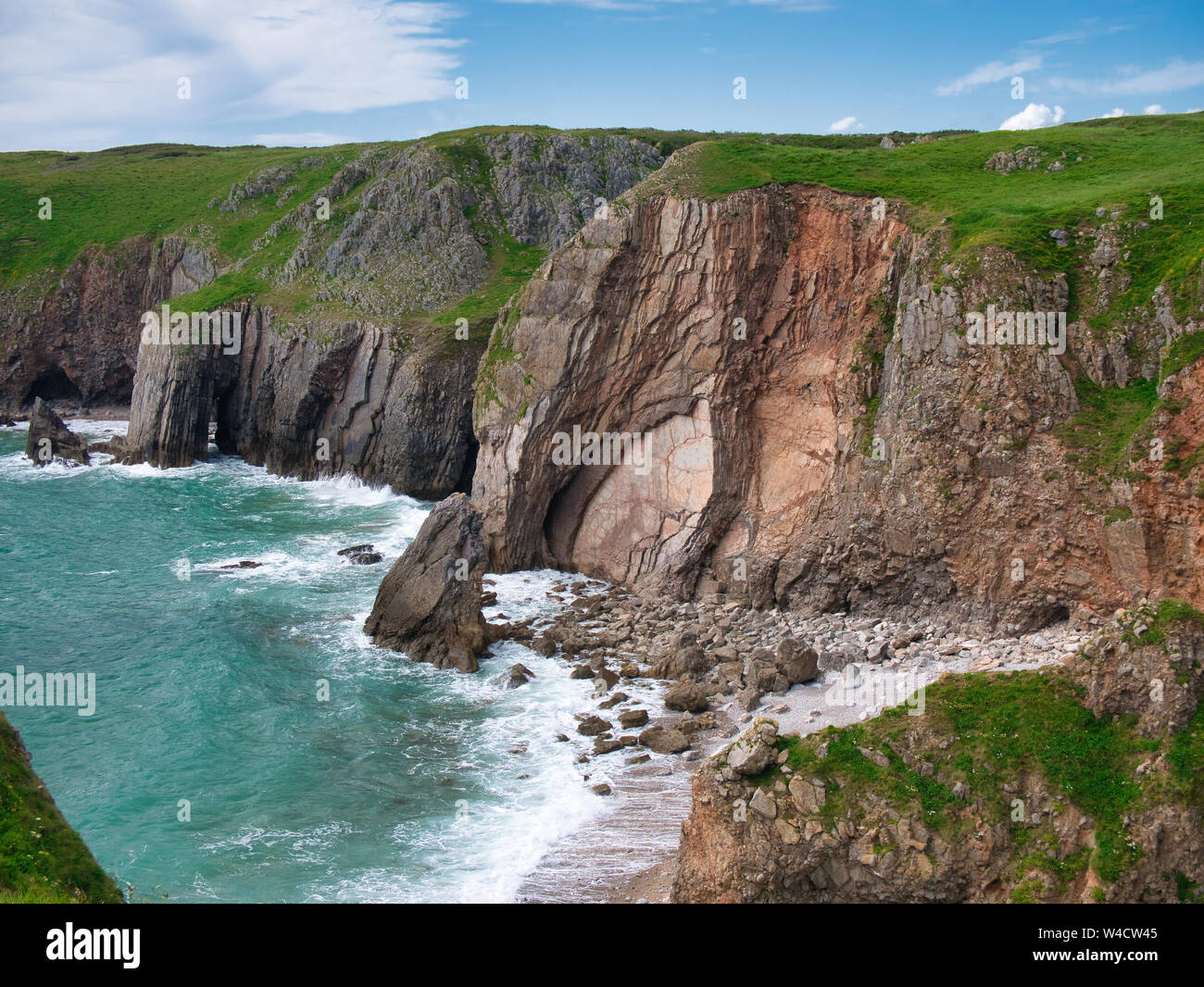 Vertically inclined rock strata in coastal cliffs near Castlemartin in Pembrokeshire, South Wales, UK, as viewed from the Coast Path Stock Photo