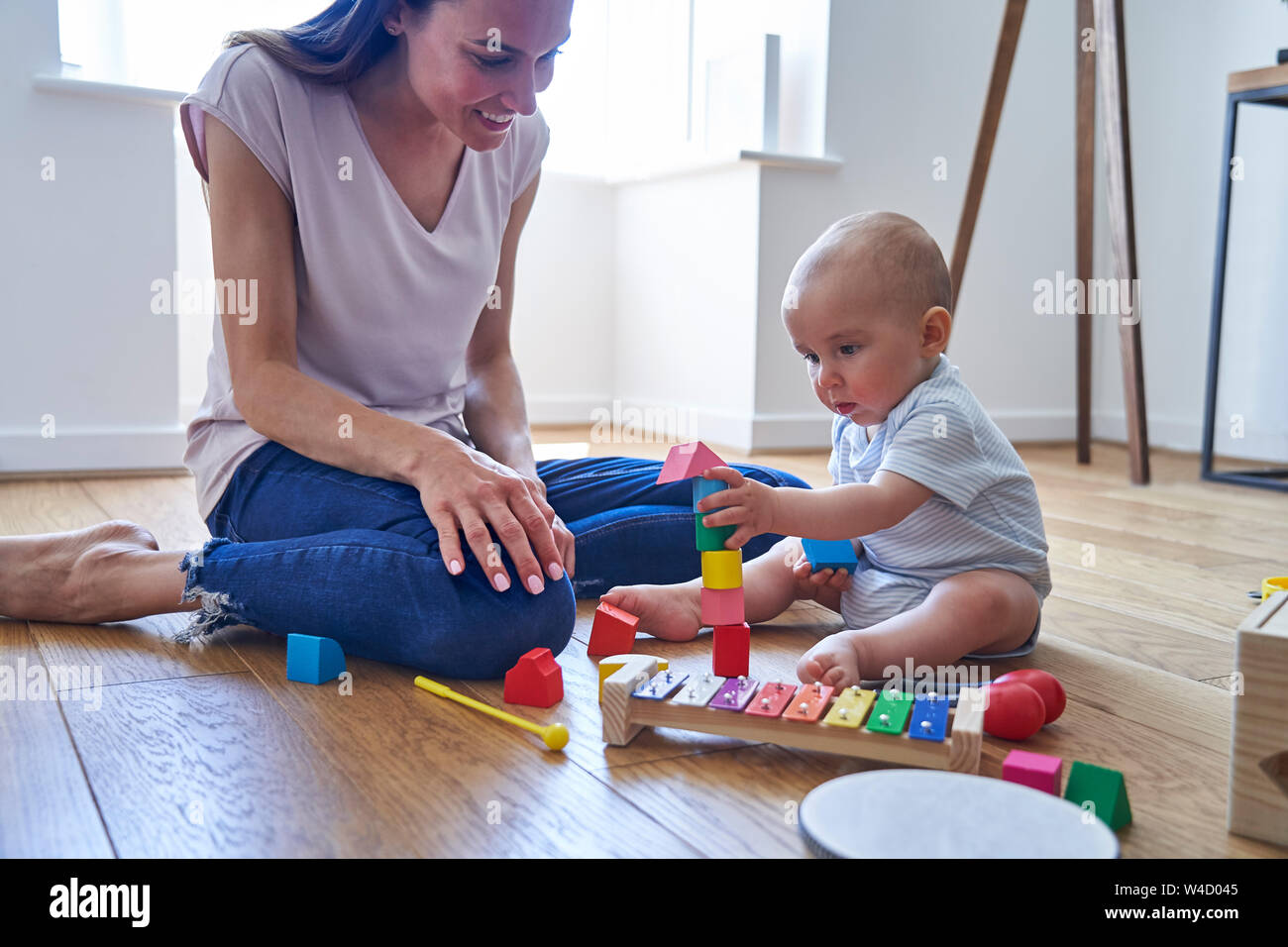 Mother With 8 Month Old Baby Son Learning Through Playing With Coloured