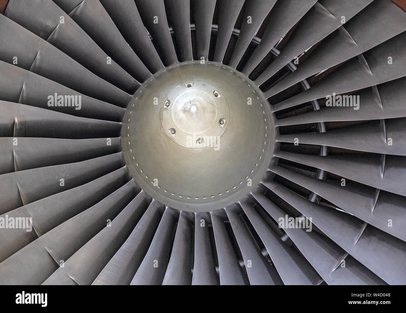Details of a large jet engine, showing the fan blades and central hub. Stock Photo