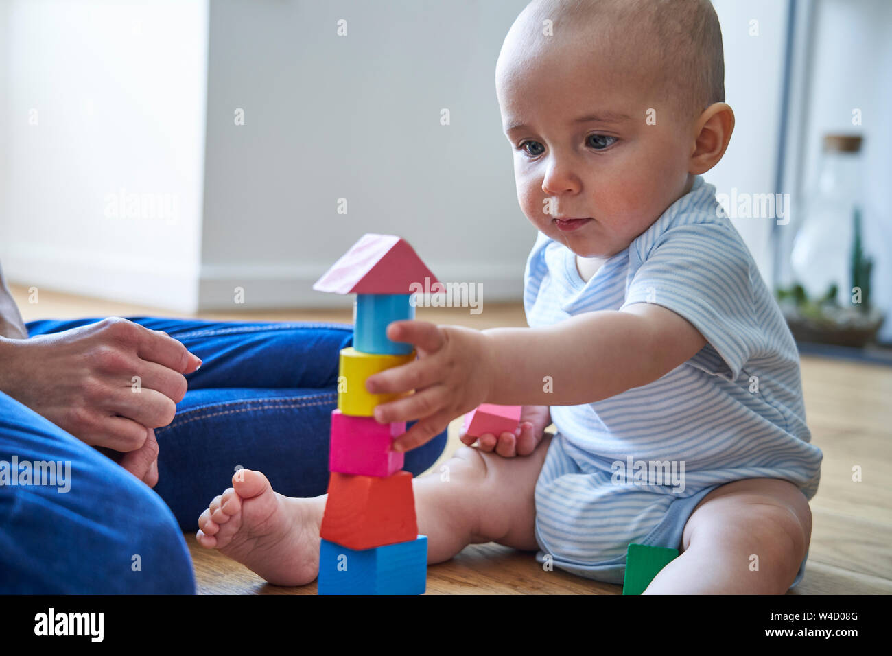 Mother With 8 Month Old Baby Son Learning Through Playing With Coloured Wooden Blocks At Home Stock Photo Alamy
