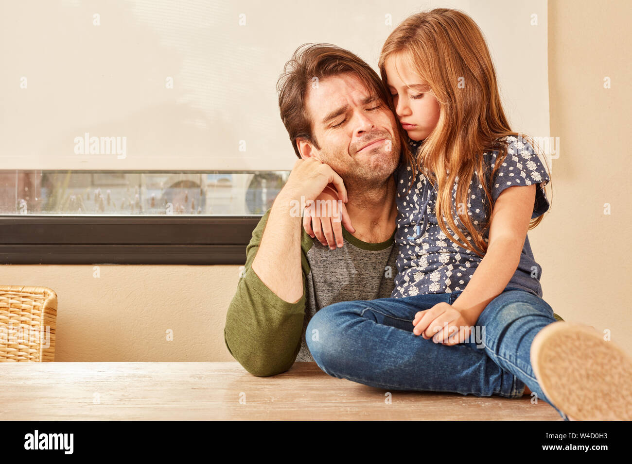 Sad or desperate father is lovingly comforted by his daughter Stock Photo