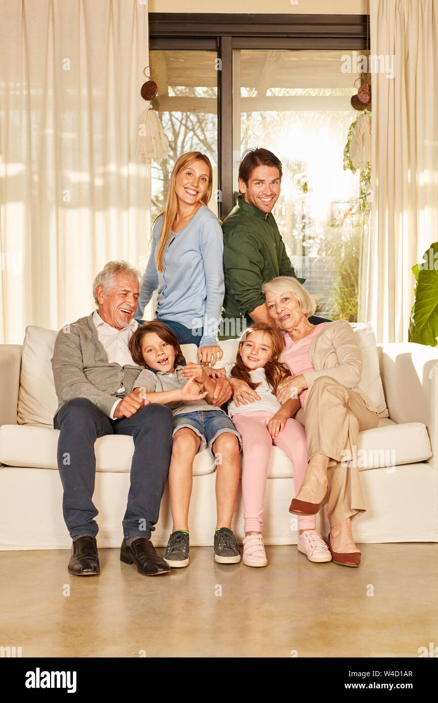 Happy extended family with grandparents and children on the sofa of senior citizen apartment Stock Photo