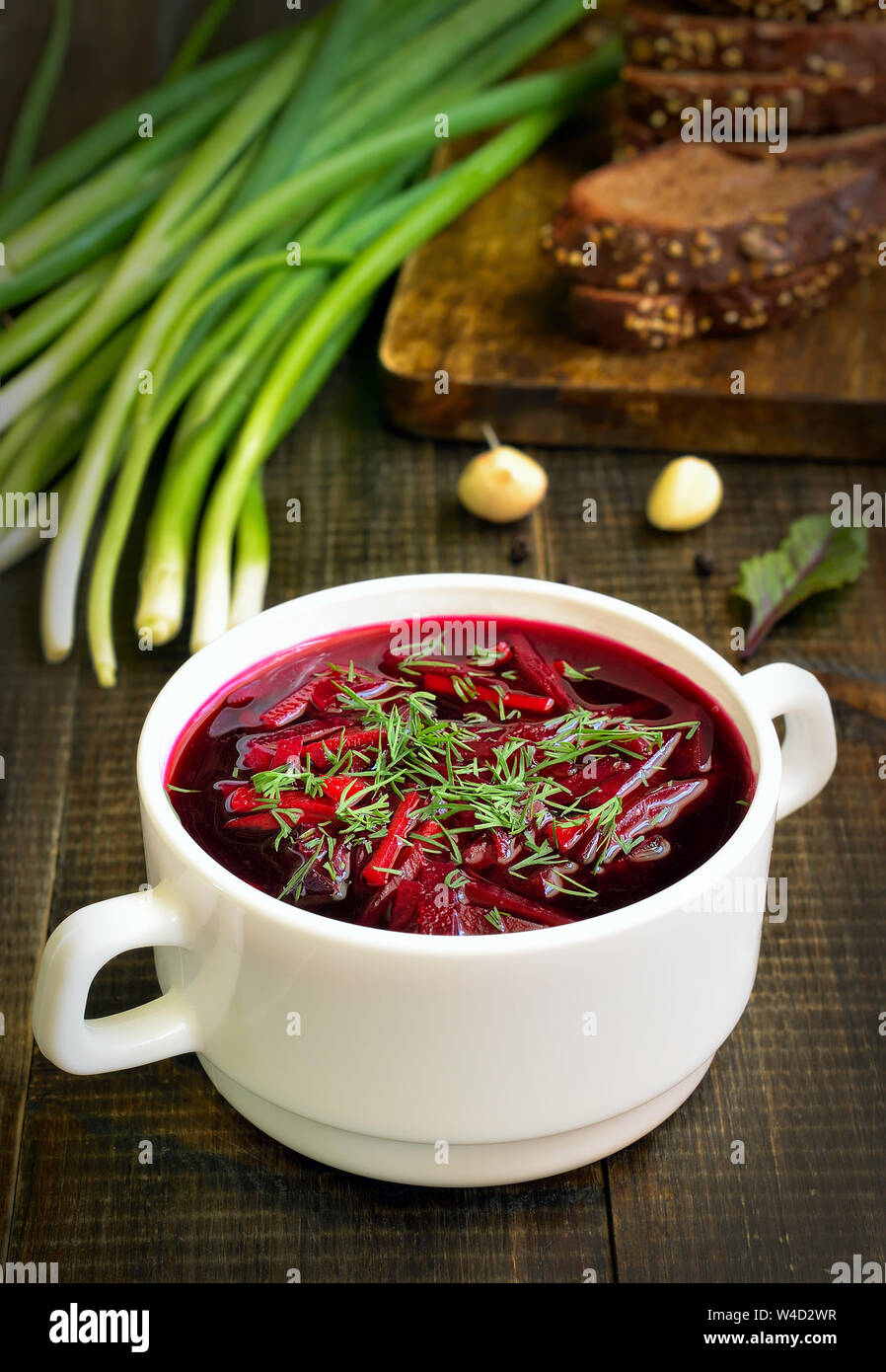 Appetizing red borscht soup with dill in white bowl Stock Photo