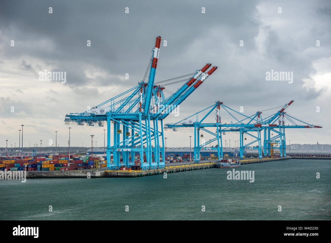 Large cranes on a cloudy day at the dock in the Port of Zeebrugge in Belgium. Stock Photo