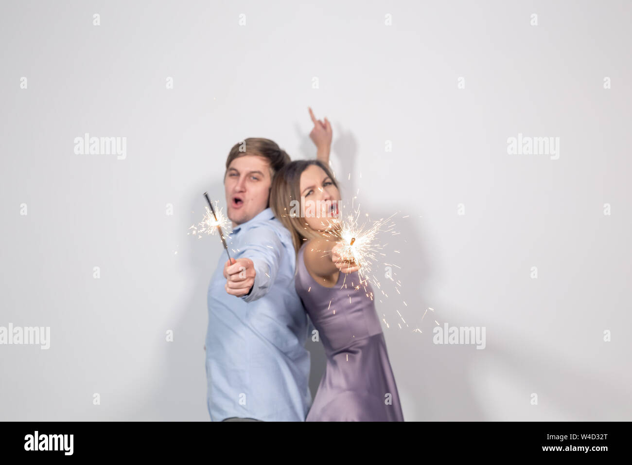 Staying Back People, party and celebrations concept - young couple with sparklers ...
