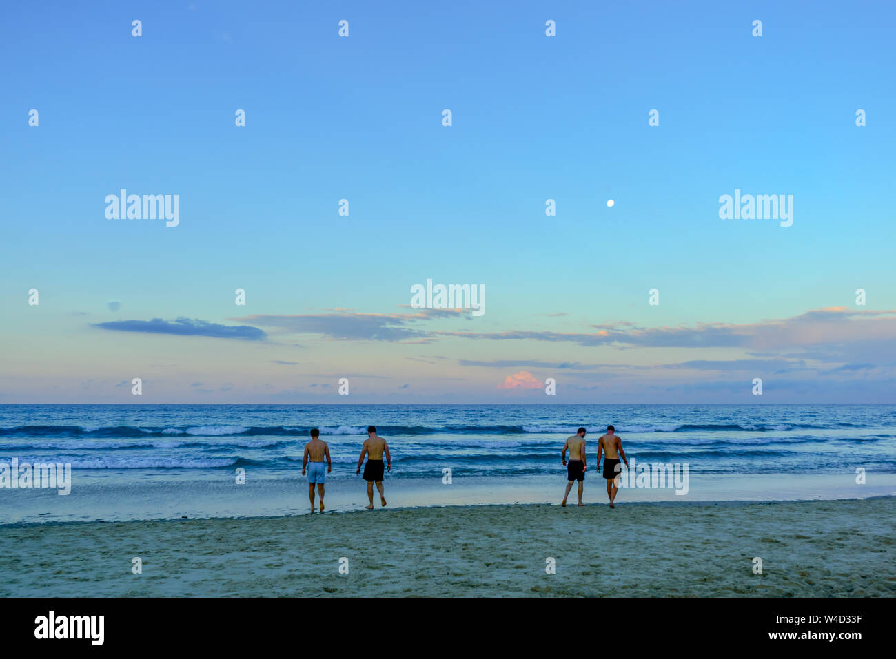 Four men on Palm Beach, Gold Coast, Queensland Stock Photo