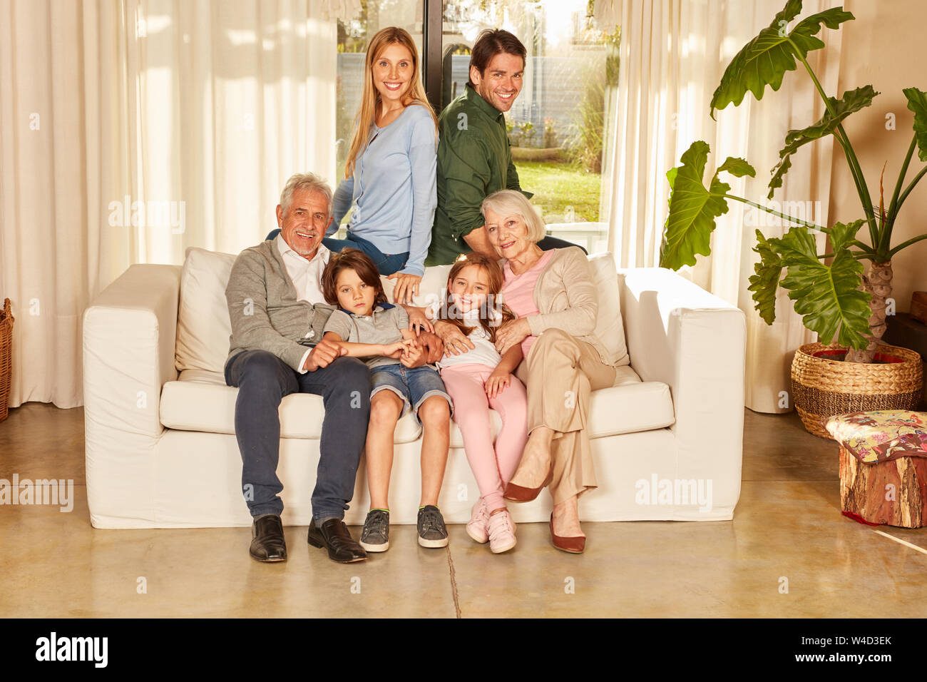 Extended family with grandparents and children together on the sofa at home Stock Photo