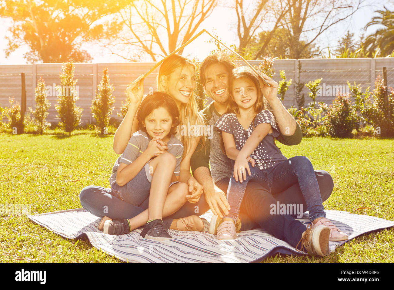 Insurance for family with house as concept with parents and children in the garden Stock Photo