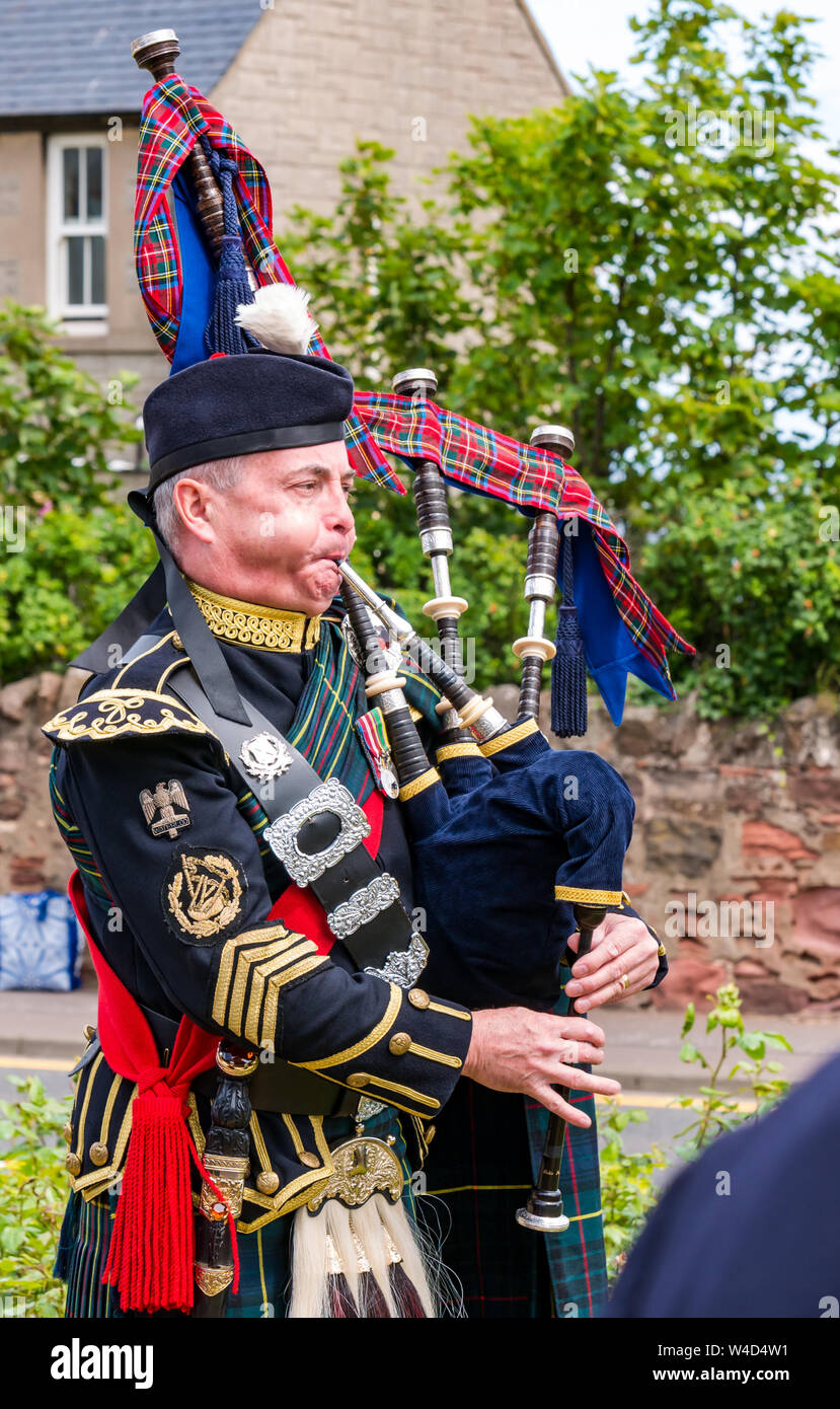 A bagpipe piper plays at a regimental ceremony, Dunbar, East Lothian, Scotland, UK Stock Photo