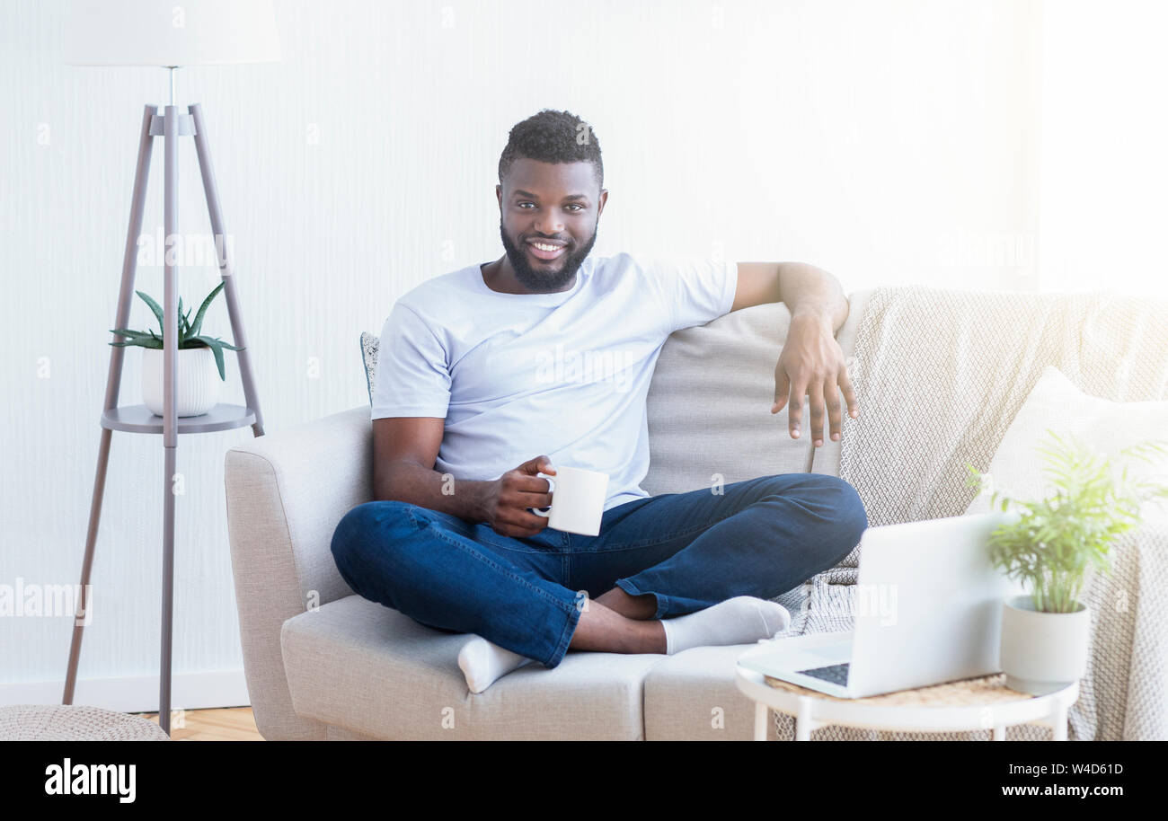 Cheerful african man enjoying rest at home office Stock Photo