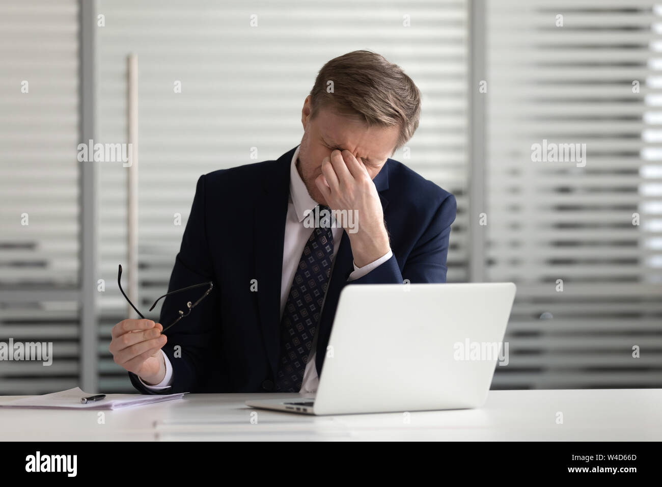 Overworked stressed businessman take off glasses tired of computer work ...