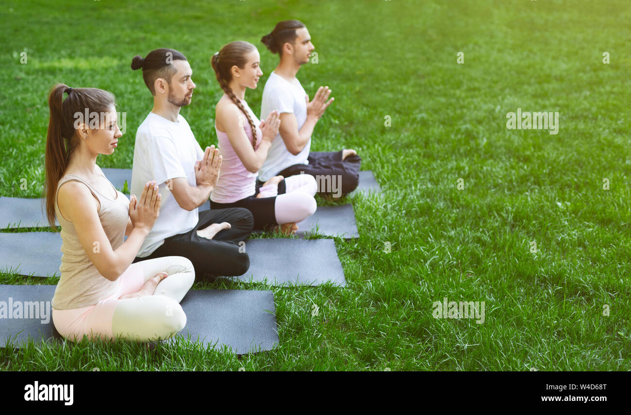 Group of people sitting on mats in lotus pose outdoors Stock Photo - Alamy