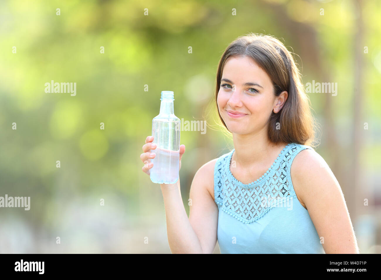 https://c8.alamy.com/comp/W4D71P/smiley-woman-holding-a-bottle-of-water-looking-at-camera-on-green-background-W4D71P.jpg