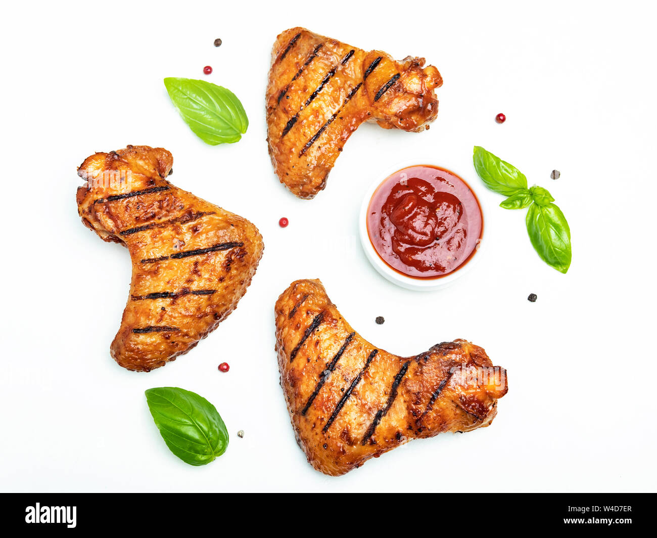 grilled chicken wings, red bbq sauce basil spices on white background Stock Photo