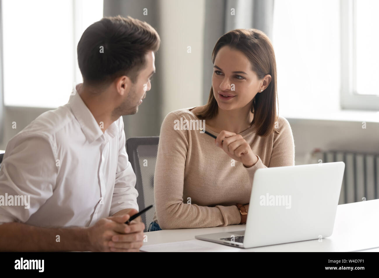 Creative male and female colleagues talking at work share ideas Stock Photo