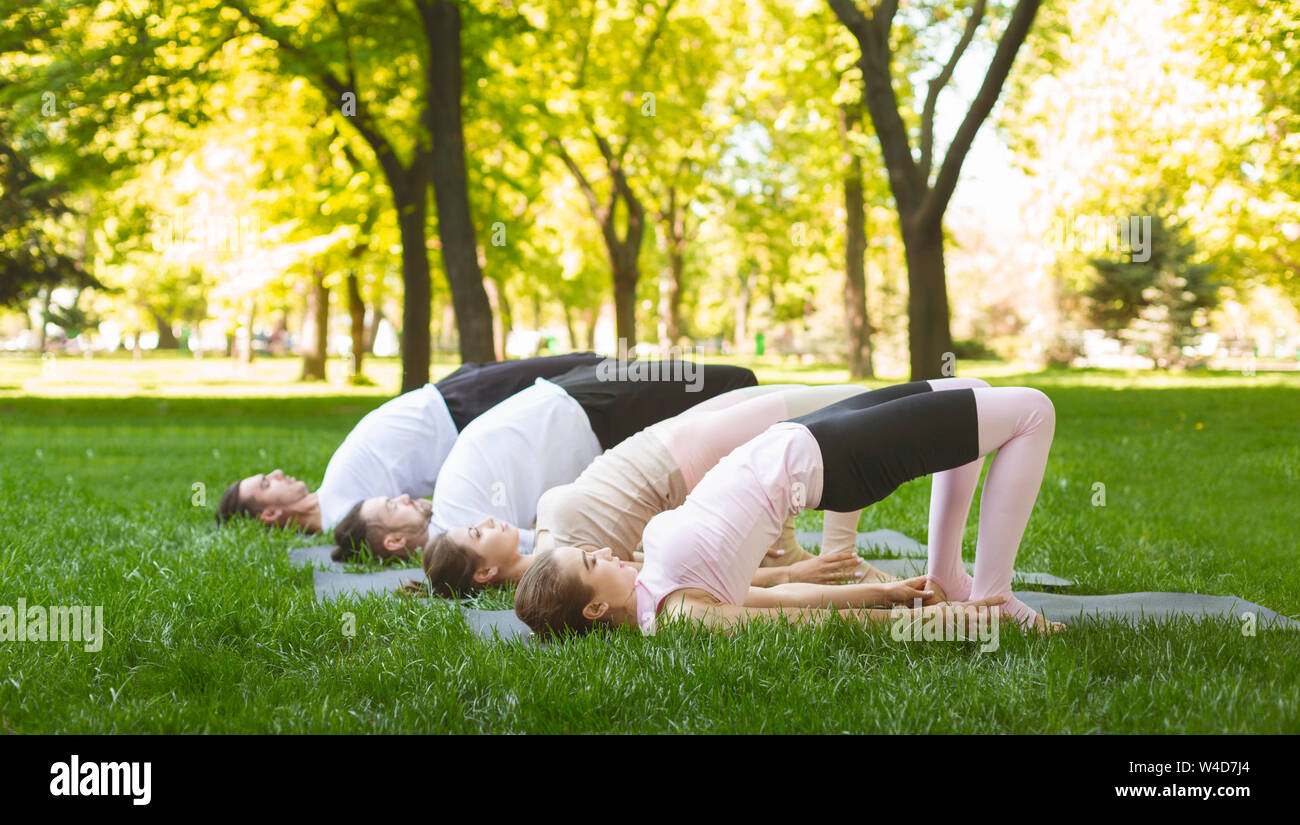 Young yoga lovers exercise outdoors, stretching in Glute Bridge pose