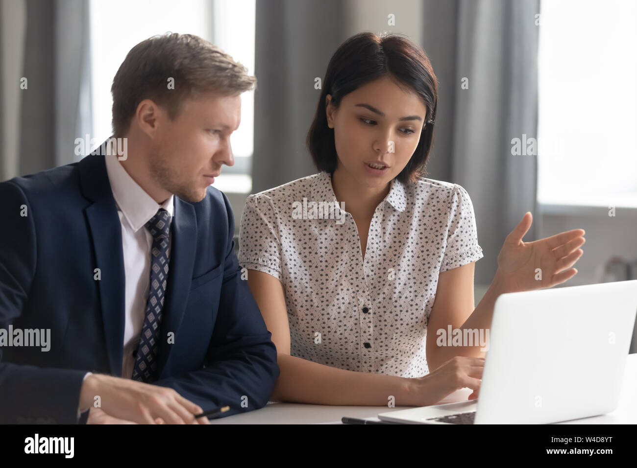 Asian manager mentor consult caucasian client teaching intern with laptop Stock Photo