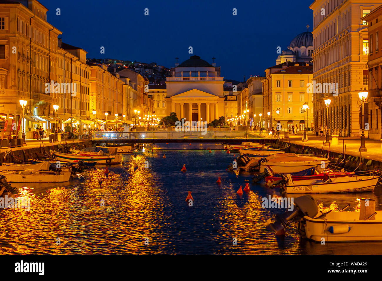 A night view on the Cathedral Chiesa di San Antonio from the bridge of Grade canal in Triest, Italy Stock Photo