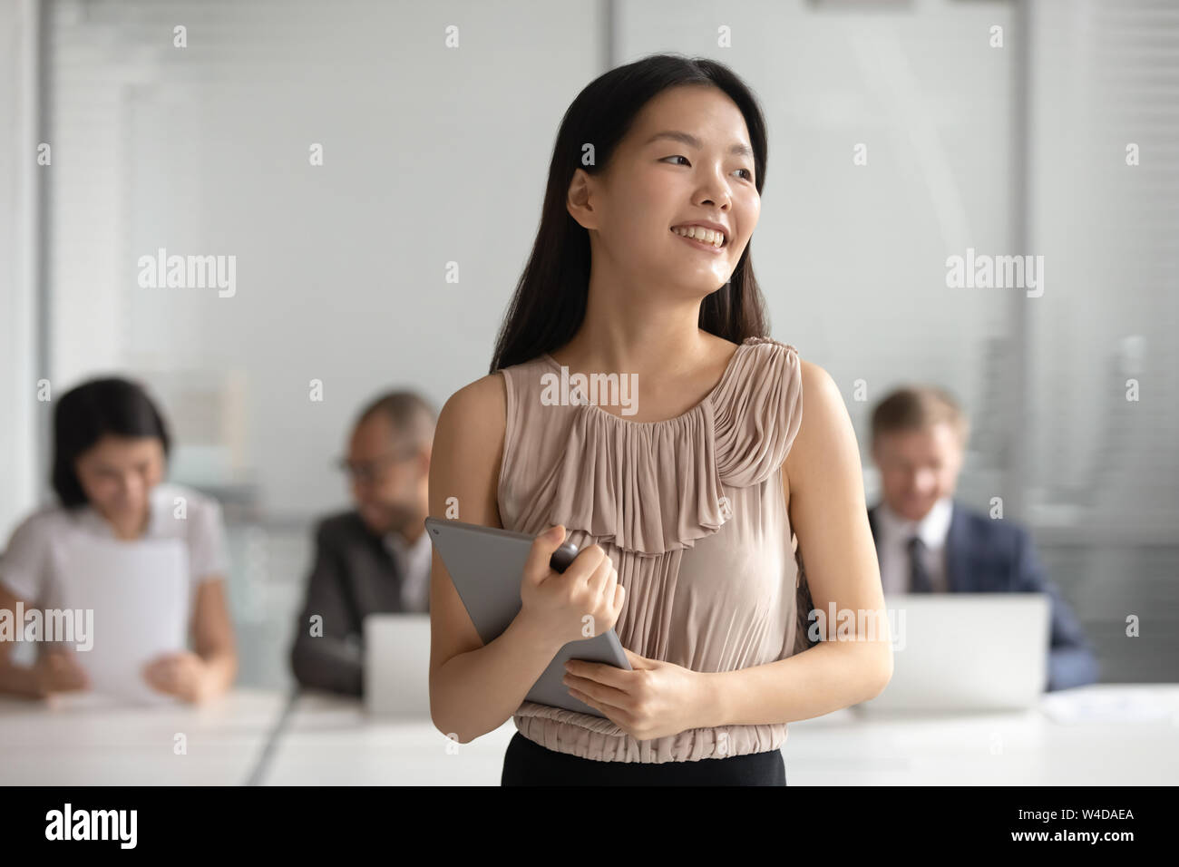 Happy dreamy asian businesswoman looking away dream of successful career Stock Photo