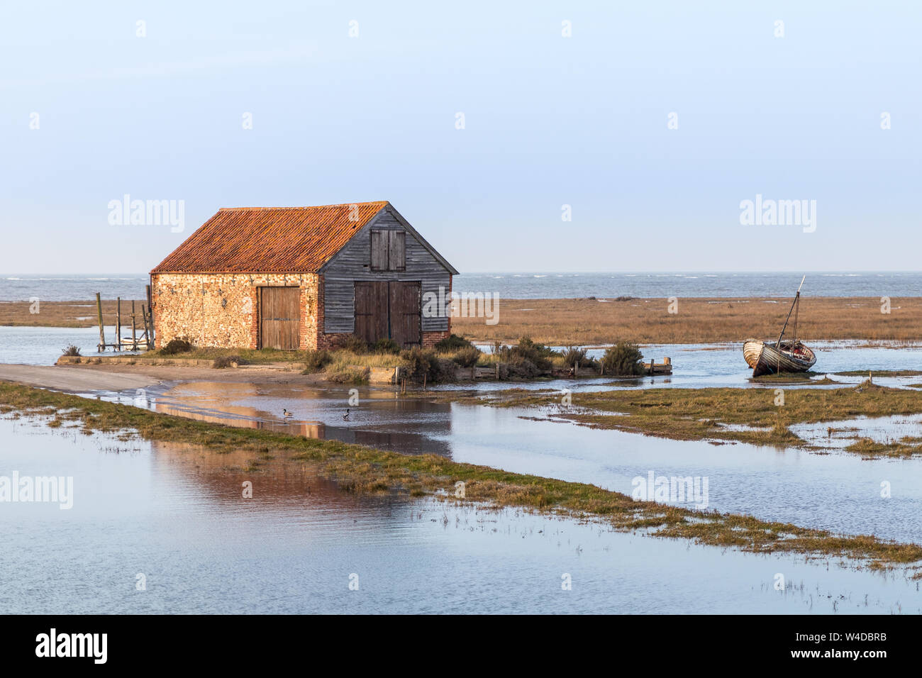 The boat house at high tide at Thornham Harbour, Norfolk, United Kingdom Stock Photo