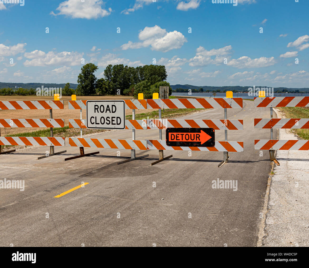 Barricades and signs warn of a road closed due to flooding along the Mississippi River Stock Photo