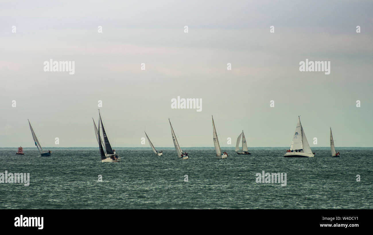 Sailing together. Group of sailboats sails on the edge of horizon during sail club regatta near