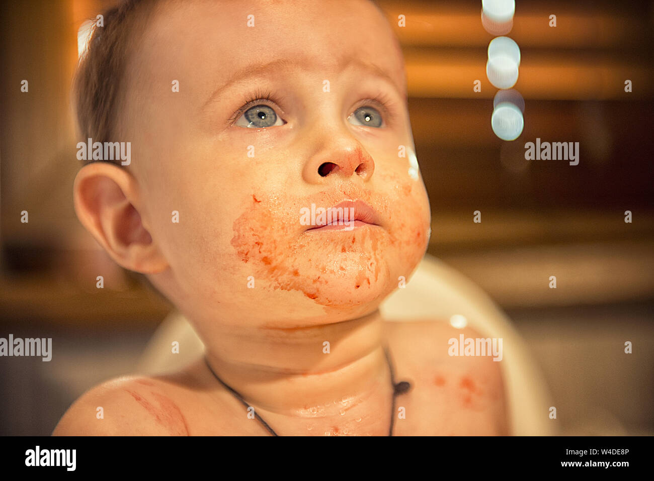 Young boy smeared in strawberry juice and asks for supplements Stock Photo