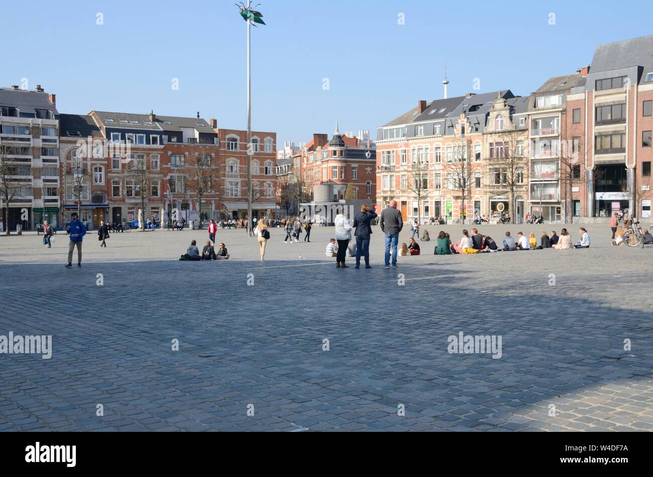 Leuven, Belgium - April 1, 2019: People at the big square where is located a giant shiny green beetle sculpture, a work by Belgian artist Jan Fabre, i Stock Photo